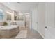 Bright and spacious bathroom with a soaking tub, tiled floors, double sinks, and glass shower at 743 Brooks Field Drive Dr, Winter Garden, FL 34787