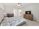 Well-lit bedroom with neutral walls and furniture, a ceiling fan, and adjacent en suite bathroom at 743 Brooks Field Drive Dr, Winter Garden, FL 34787