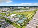 Stunning aerial view of a community with a pool, tennis courts, and beautiful landscaping on a sunny day at 7974 Penrose Pl, Wildwood, FL 34785