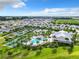 Expansive aerial view of a community with various amenities and well-maintained landscaping under a bright sky at 7974 Penrose Pl, Wildwood, FL 34785