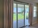Large sliding glass door with view of landscaped backyard and covered patio at 7974 Penrose Pl, Wildwood, FL 34785
