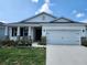 Charming single-story home with a well-manicured lawn and a two-car garage at 7974 Penrose Pl, Wildwood, FL 34785