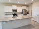 Modern kitchen with stainless steel appliances, granite countertops and large island at 7974 Penrose Pl, Wildwood, FL 34785