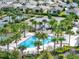 A serene swimming pool surrounded by lush palm trees and plenty of lounge chairs for relaxing by the water at 7974 Penrose Pl, Wildwood, FL 34785