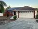 Charming red home with a two-car garage, solar panels, and a well-maintained front yard and walkway at 808 Chamberlain Loop, Lake Wales, FL 33853