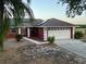 Charming red home with a two-car garage, solar panels, and a well-maintained front yard and walkway at 808 Chamberlain Loop, Lake Wales, FL 33853