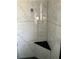Corner shower with marble tile and corner shelf providing storage at 808 Chamberlain Loop, Lake Wales, FL 33853