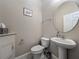 Cozy powder room featuring a pedestal sink, toilet, and decorative accents at 8387 Bridgeport Bay Cir, Mount Dora, FL 32757