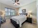 Comfortable bedroom featuring neutral tones, a window with blinds, ceiling fan and carpeted flooring at 8387 Bridgeport Bay Cir, Mount Dora, FL 32757