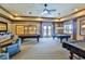 Well-lit billiards room includes multiple pool tables, comfortable seating, and vintage-style decor at 8387 Bridgeport Bay Cir, Mount Dora, FL 32757