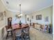 The dining room is furnished with a wooden table, wicker chairs, and crown moulding at 8387 Bridgeport Bay Cir, Mount Dora, FL 32757