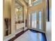 Light-filled foyer with decorative mirror, tile flooring, and elegant front door at 8387 Bridgeport Bay Cir, Mount Dora, FL 32757
