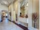 Hallway featuring tile flooring, decorative mirror, and access to other rooms in the home at 8387 Bridgeport Bay Cir, Mount Dora, FL 32757
