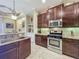 Kitchen with stainless steel appliances, granite countertops, wood cabinets, and an island with seating at 8387 Bridgeport Bay Cir, Mount Dora, FL 32757
