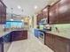 Spacious kitchen with stainless steel appliances, granite countertops, and ample cabinet space with tile flooring at 8387 Bridgeport Bay Cir, Mount Dora, FL 32757