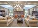 Cozy library space features comfortable couches, armchairs, and extensive bookshelves for relaxing with a book at 8387 Bridgeport Bay Cir, Mount Dora, FL 32757