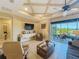 Comfortable living room with coffered ceilings, tv, sliding glass doors to the outside at 8387 Bridgeport Bay Cir, Mount Dora, FL 32757