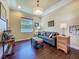Cozy living room features wood flooring, a comfortable couch, and stylish decor with natural lighting at 8387 Bridgeport Bay Cir, Mount Dora, FL 32757