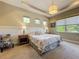 The main bedroom has neutral walls, tray ceiling, and carpeted floor at 8387 Bridgeport Bay Cir, Mount Dora, FL 32757