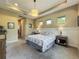 The spacious main bedroom has a tray ceiling and calming neutral color scheme at 8387 Bridgeport Bay Cir, Mount Dora, FL 32757