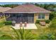 Aerial view of the cozy screened-in patio featuring lounge chairs and a grill at 8387 Bridgeport Bay Cir, Mount Dora, FL 32757