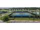 View of tennis courts surrounded by lush landscaping and a serene lake, creating a picturesque recreational space at 8387 Bridgeport Bay Cir, Mount Dora, FL 32757