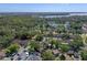Panoramic aerial shot of a residential area nestled amidst lush trees and a serene lake, showcasing the community and landscape at 903 Belle Oak Dr, Leesburg, FL 34748