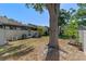 Spacious backyard featuring mature trees, green grass, a privacy fence, and a patio area perfect for outdoor enjoyment at 903 Belle Oak Dr, Leesburg, FL 34748