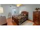 Bedroom featuring hardwood floors, a queen bed, and ample storage space with a dresser and closet at 903 Belle Oak Dr, Leesburg, FL 34748