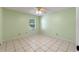 Clean, empty bedroom with tile flooring and natural light from the large window at 903 Belle Oak Dr, Leesburg, FL 34748