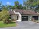 Charming exterior of the two-story townhome featuring attached garages and lush landscaping at 903 Belle Oak Dr, Leesburg, FL 34748