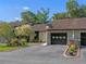 Charming townhome featuring an attached garage, landscaped yard, and black accents at 903 Belle Oak Dr, Leesburg, FL 34748