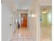 Light and bright foyer with tile floors and a charming wooden front door at 903 Belle Oak Dr, Leesburg, FL 34748