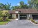 Charming single-story home with a well-manicured lawn, black garage doors, and inviting front entrance at 903 Belle Oak Dr, Leesburg, FL 34748