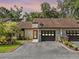 Charming single-story home with a well-manicured lawn, black garage doors, and inviting front entrance at 903 Belle Oak Dr, Leesburg, FL 34748