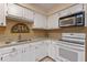 Bright kitchen with white cabinets, granite countertops, and modern appliances at 903 Belle Oak Dr, Leesburg, FL 34748