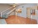 Hardwood floors, white staircase, and an opening through to the kitchen are features of the living room at 903 Belle Oak Dr, Leesburg, FL 34748