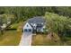 Beautiful two-story home with a manicured lawn, long gray driveway and mature trees at 9134 Mossy Oak Ln, Clermont, FL 34711