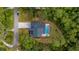 Aerial view of a home with a private pool, patio, long driveway and mature trees at 9134 Mossy Oak Ln, Clermont, FL 34711