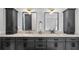 Bathroom featuring a dual sink vanity with marble countertops, modern lighting, and updated fixtures at 9134 Mossy Oak Ln, Clermont, FL 34711