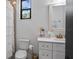 Well-lit bathroom features a shower with a white curtain, a white vanity, and a window at 9134 Mossy Oak Ln, Clermont, FL 34711