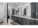 Modern bathroom featuring dual sinks, marble countertops, and sleek black fixtures at 9134 Mossy Oak Ln, Clermont, FL 34711