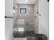 Stylish walk-in shower featuring glass door, modern fixtures, and mosaic tile accents at 9134 Mossy Oak Ln, Clermont, FL 34711