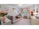 Charming bedroom with floral accents, a cozy daybed, and soft pink decor at 9134 Mossy Oak Ln, Clermont, FL 34711