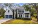 Charming two-story home with a manicured lawn, gray driveway, and black trimmed windows and doors at 9134 Mossy Oak Ln, Clermont, FL 34711
