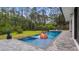 Stunning backyard pool featuring mature trees and a playful orange slide at 9134 Mossy Oak Ln, Clermont, FL 34711