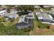 Aerial view of home featuring solar panels, screened in lanai and green backyard at 923 Oleander St, The Villages, FL 32159