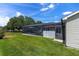 Expansive backyard showcasing a screened-in patio area and well-maintained lawn at 923 Oleander St, The Villages, FL 32159
