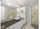 Bright bathroom featuring a large mirror, granite countertop, vessel sink, and glass-enclosed shower at 923 Oleander St, The Villages, FL 32159