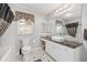 Bright bathroom features tile floors, a large mirror, single sink, and a shower/tub combo at 923 Oleander St, The Villages, FL 32159